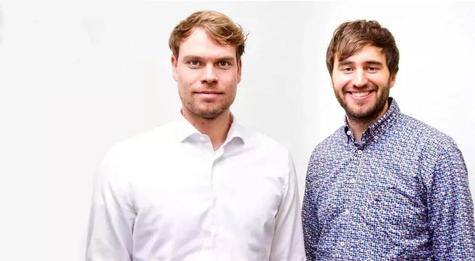 Das Bild zeigt die beiden Gründer vom Startup Medizinio vor einer weißen Wand.